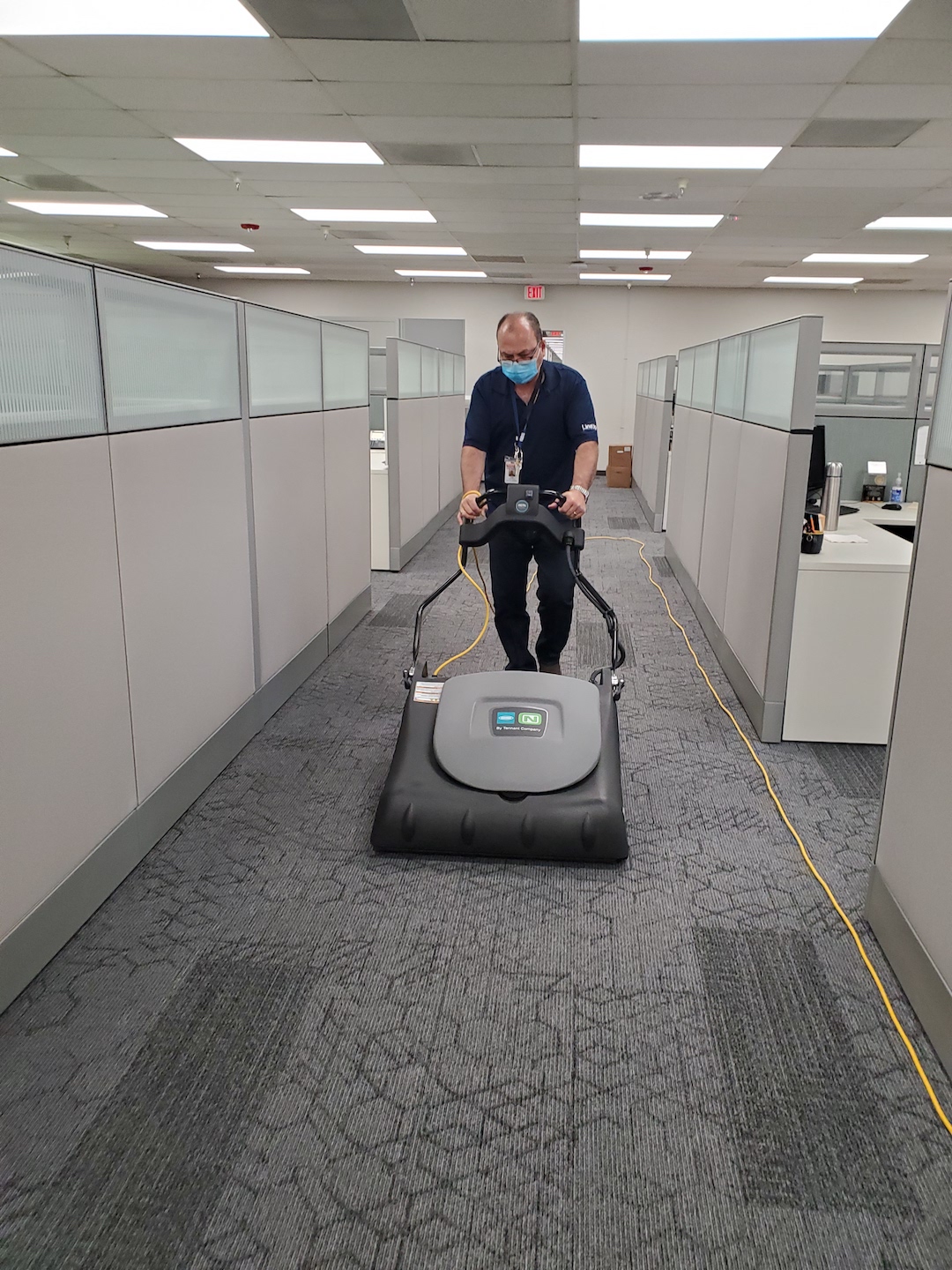 Laborer cleaning office corridor